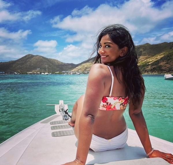 Woman sitting on front of the boat looking back at camera and smiling